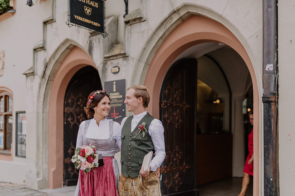 Das Braupaar blickt sich glücklich vor dem Standesamt in Landshut in die Augen