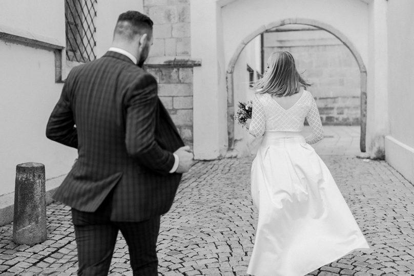 Brautpaar gehend von hinten mit schwingendem Rock in Deggendorf