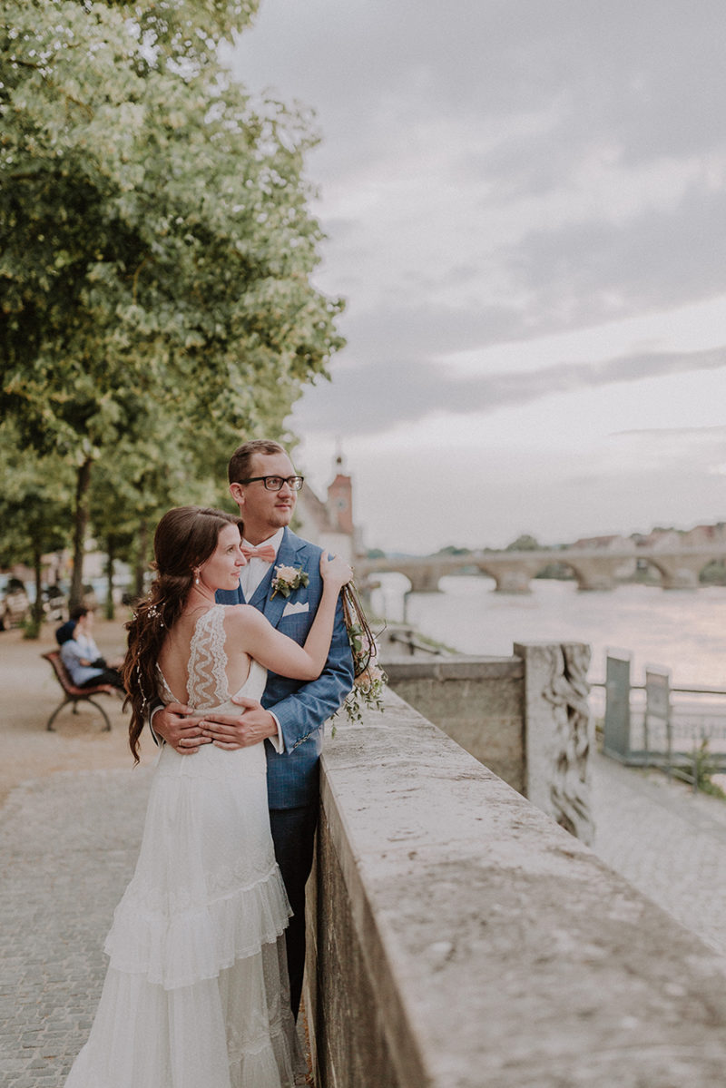 Brautpaar auf die Donau blickend.