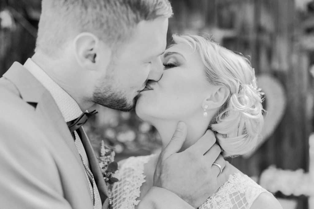 Schwarz-Weiß Foto von küssendem Brautpaar