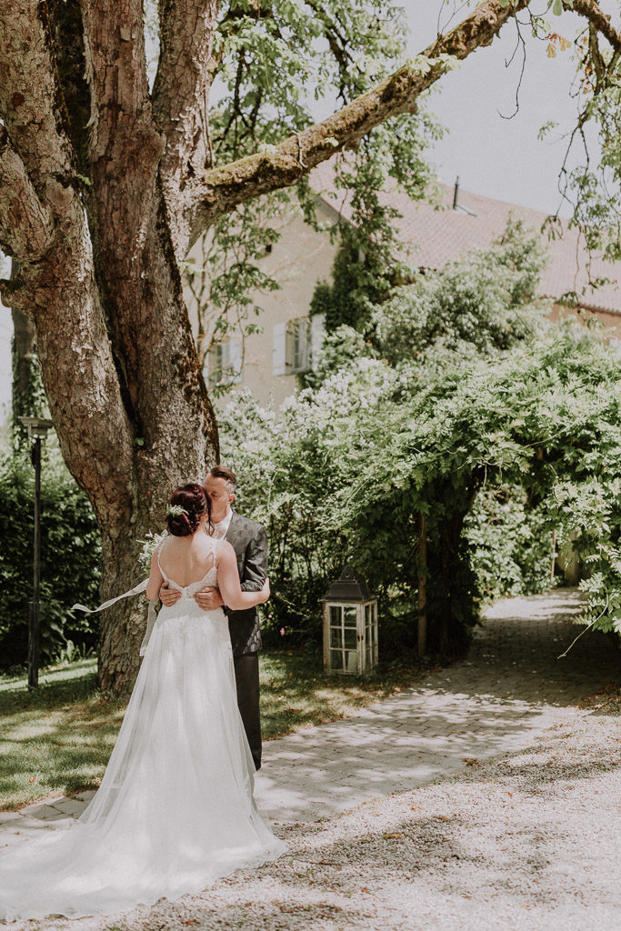Brautpaar küsst sich im Schlossgarten vor märchenhafter Kulisse