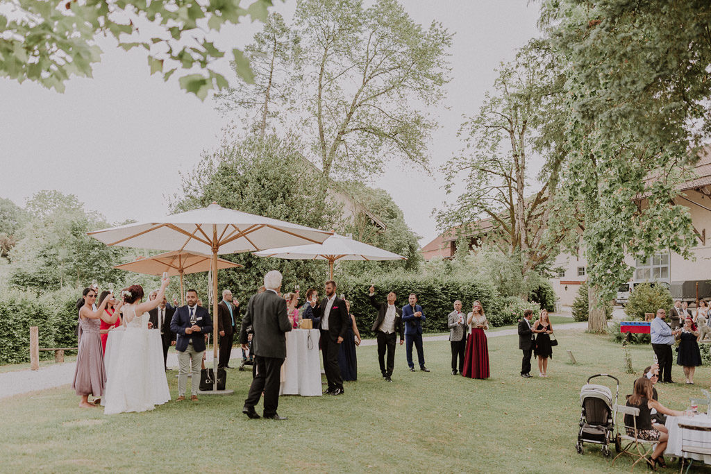 Sich zuprostendes Brautpaar im Schlossgarten