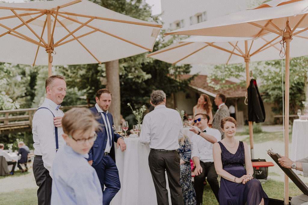 Hochzeitsgäste mit Karikateur im Schlossgarten